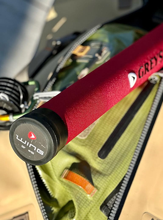 Red fishing rod handle with 'Lune' branding on a green bag